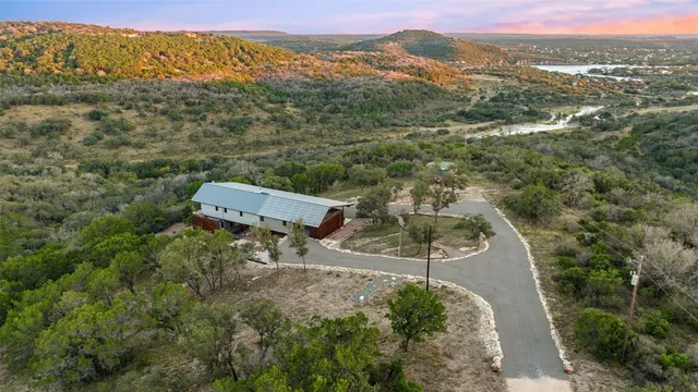 an aerial view of a house with a mountain
