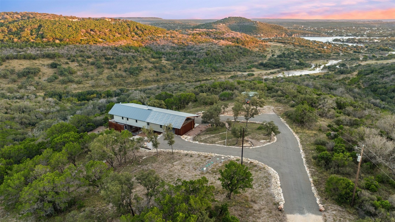 an aerial view of a house with a mountain