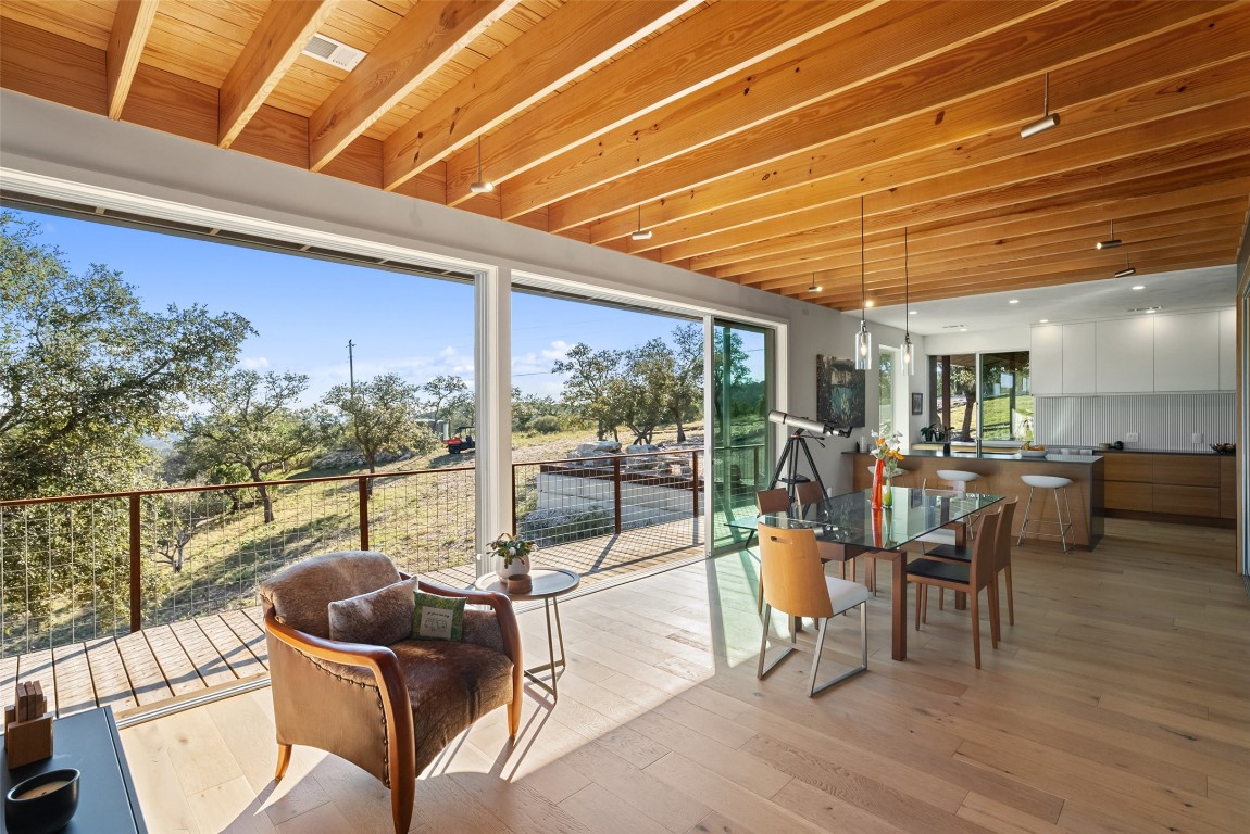 2037 Wolf Creek Ranch Road Burnet, TX 78611 - Photo 16 of 40 a view of a patio with dining table and chairs with wooden floor and fence