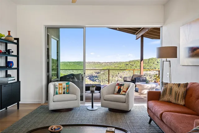 a living room with furniture wooden floor and a large window