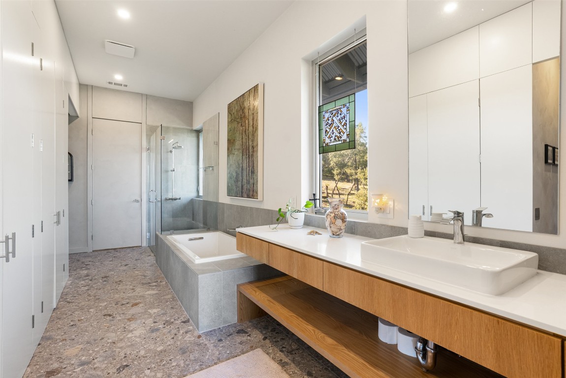 2037 Wolf Creek Ranch Road Burnet, TX 78611 - Photo 25 of 40 a bathroom with a double vanity sink a mirror and a bathtub