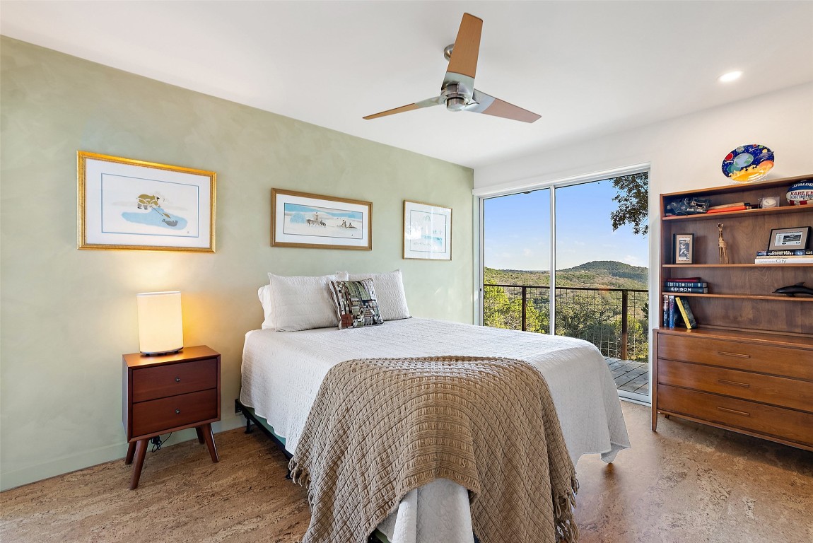 2037 Wolf Creek Ranch Road Burnet, TX 78611 - Photo 32 of 40 a bedroom with a bed and a chandelier