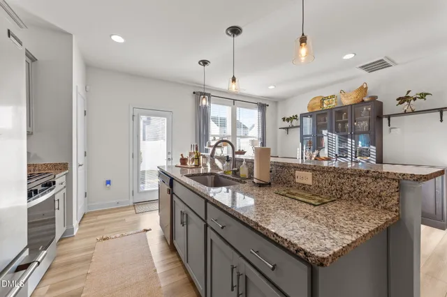 a kitchen with stainless steel appliances granite countertop a sink stove and refrigerator