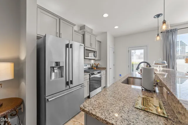 a kitchen with stainless steel appliances granite countertop a refrigerator sink and stove