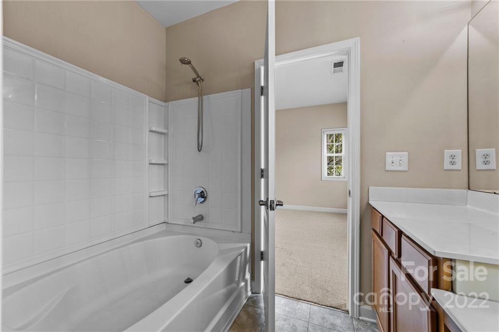 10559 Rocky Ford Club Road Charlotte, NC 28078 - Photo 12 of 18 a bathroom with a tub shower vanity and a sink