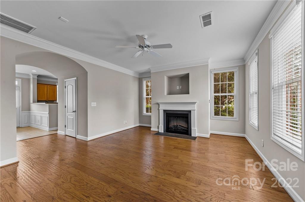 10559 Rocky Ford Club Road Charlotte, NC 28078 - Photo 2 of 18 an empty room with wooden floor fireplace and windows