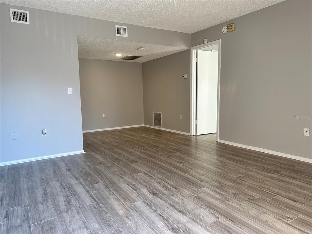 5993 Village Circle North, Unit GE Orlando, FL 32822 - Photo 2 of 16 a view of an empty room with wooden floor