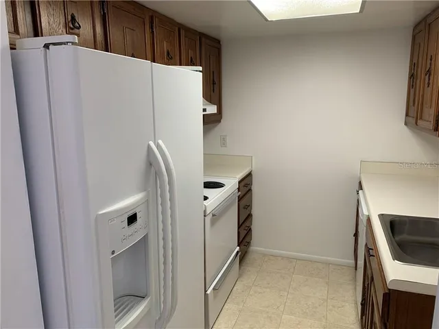 a white refrigerator freezer and a stove sitting inside of a kitchen
