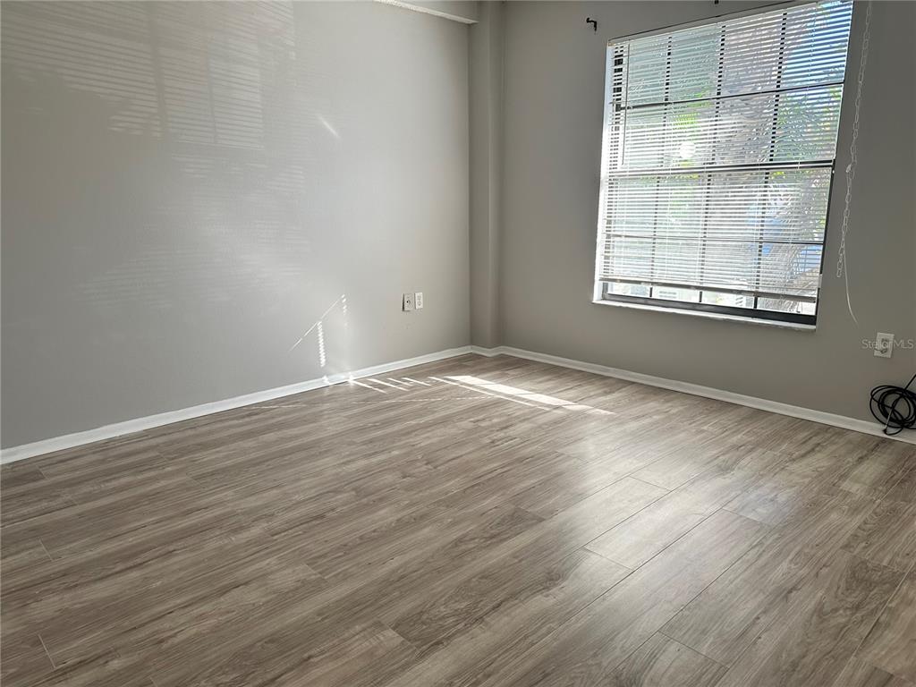5993 Village Circle North, Unit GE Orlando, FL 32822 - Photo 9 of 16 a view of an empty room with wooden floor and a window