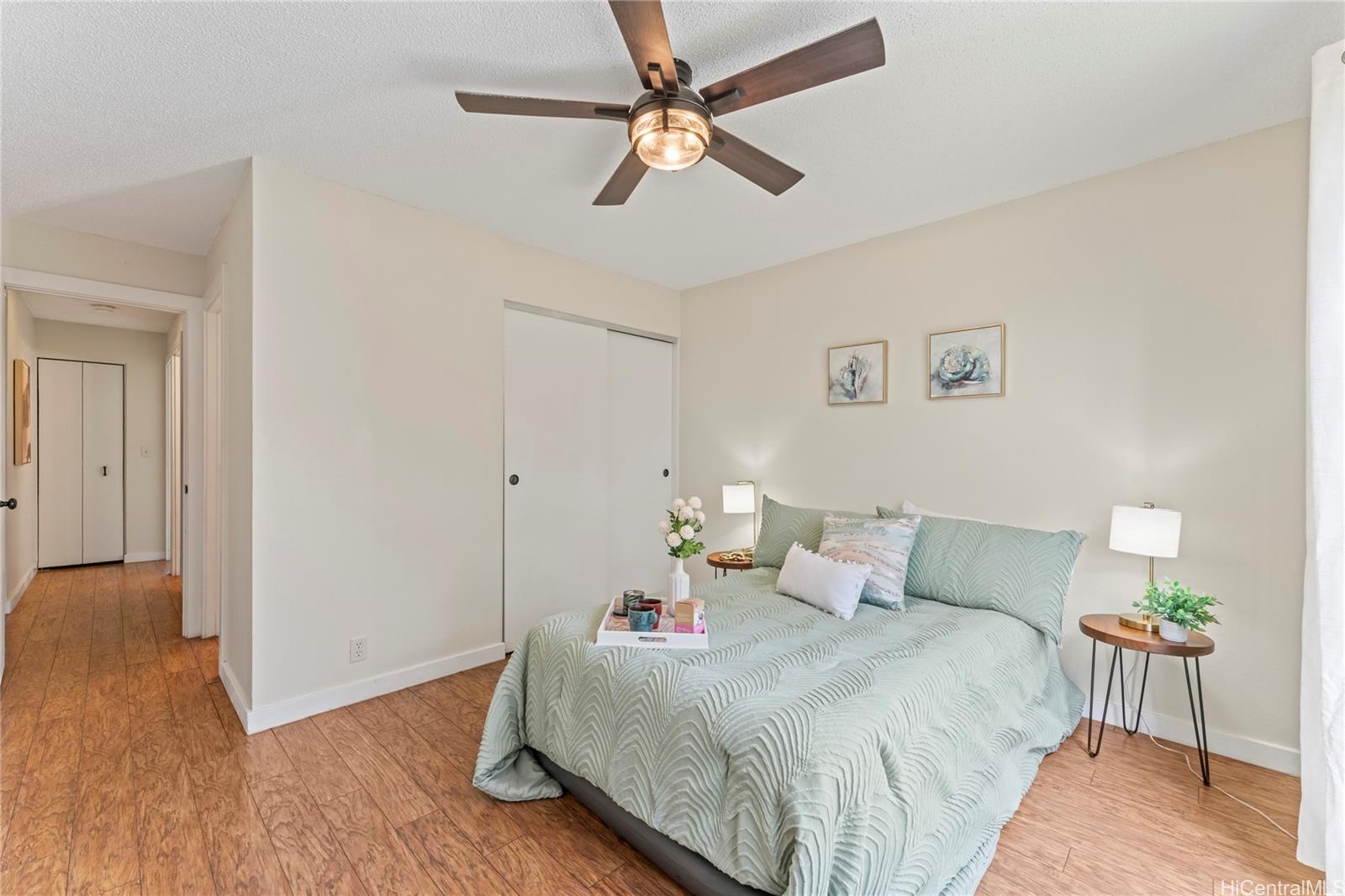 92-1136 Hame Street, Unit 10102 Kapolei, HI 96707 - Photo 12 of 22 a bedroom with a bed and wooden floor