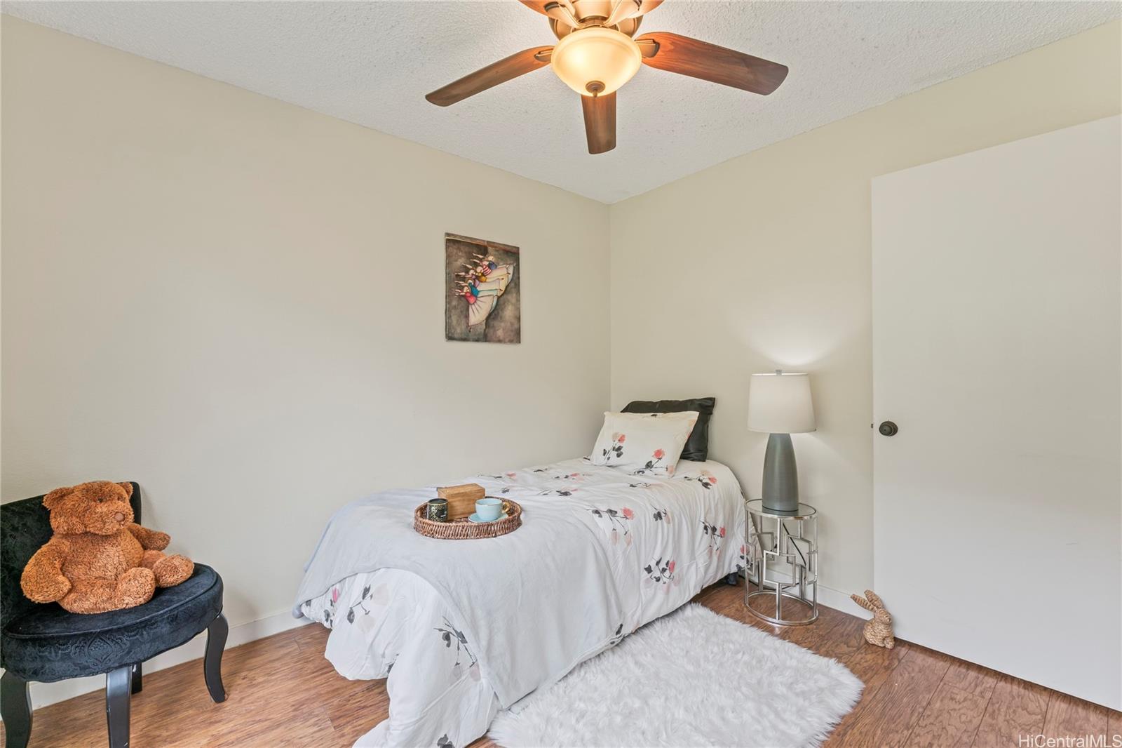 92-1136 Hame Street, Unit 10102 Kapolei, HI 96707 - Photo 17 of 22 a bedroom with a bed and wooden floor
