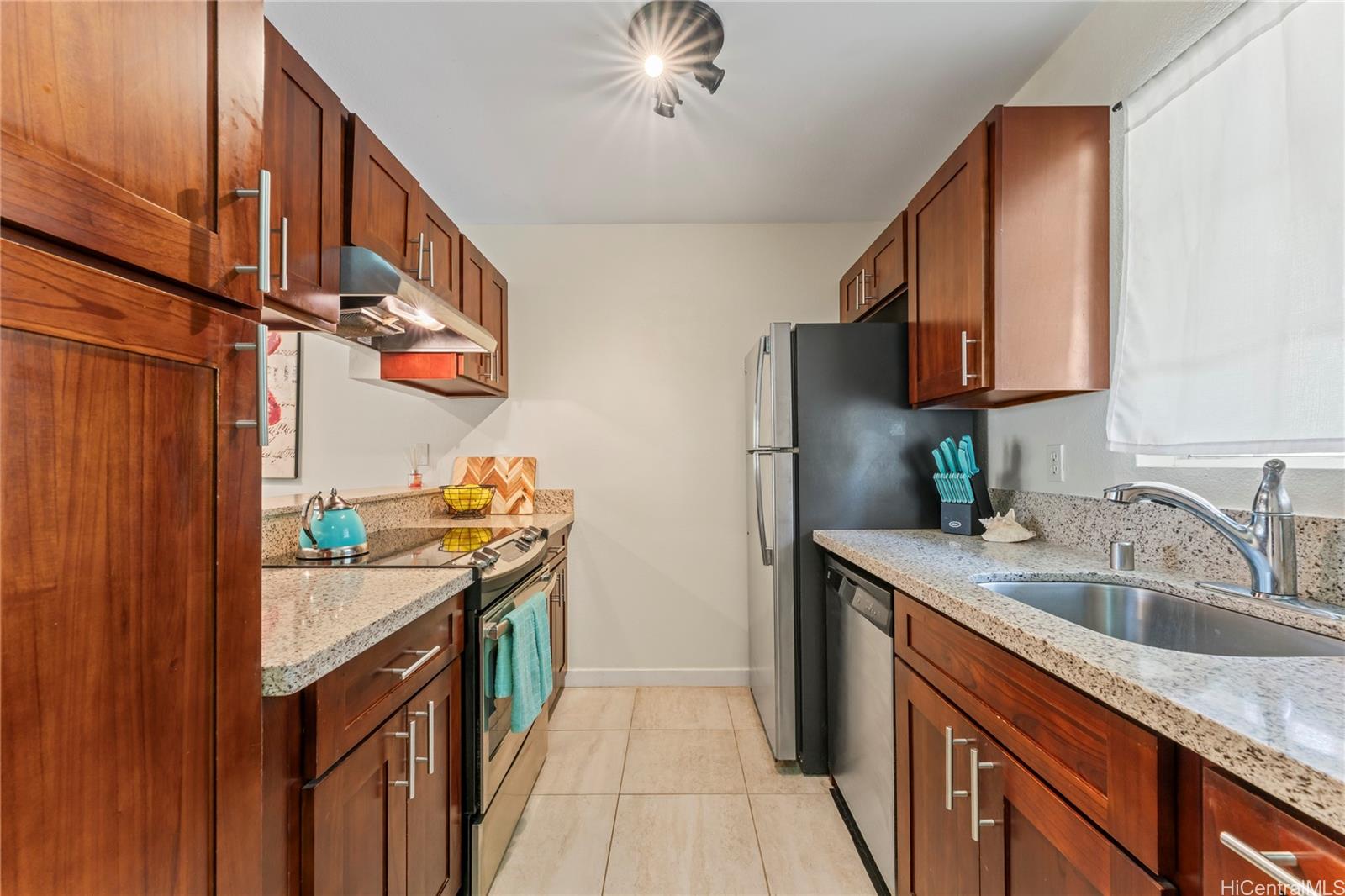 92-1136 Hame Street, Unit 10102 Kapolei, HI 96707 - Photo 5 of 22 a kitchen with stainless steel appliances granite countertop a sink stove and refrigerator