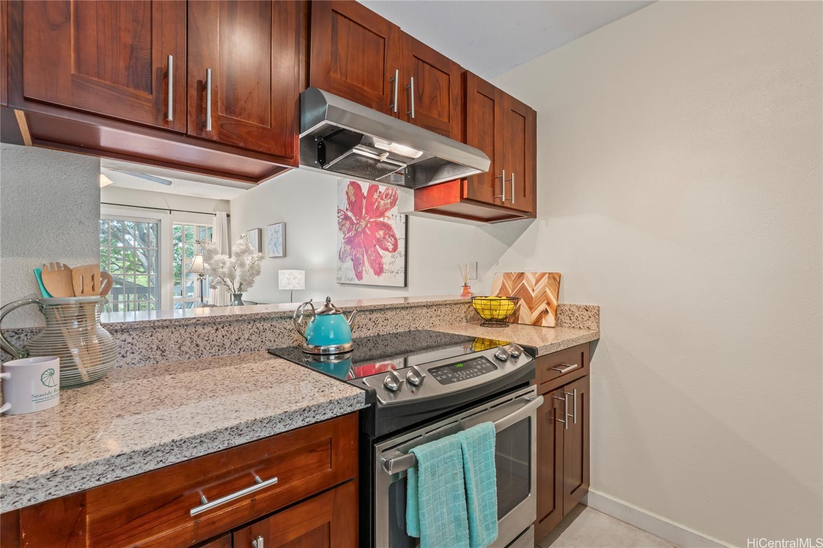 92-1136 Hame Street, Unit 10102 Kapolei, HI 96707 - Photo 7 of 22 a kitchen with stainless steel appliances granite countertop a stove a sink and a microwave