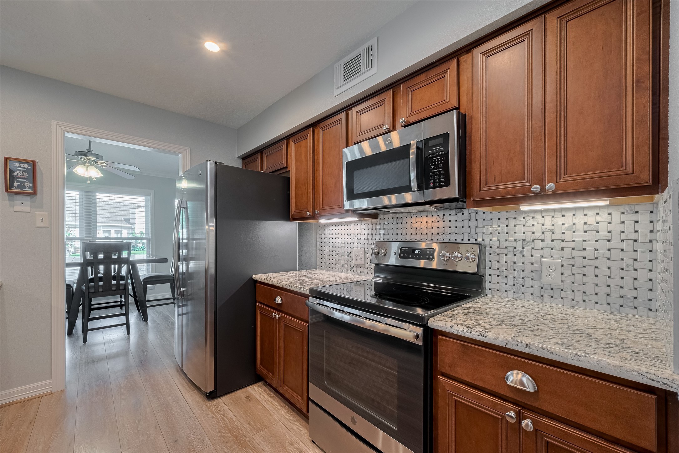 64 Hideaway Drive Friendswood, TX 77546 - Photo 11 of 33 a kitchen with stainless steel appliances granite countertop wooden cabinets a stove top oven a sink and dishwasher