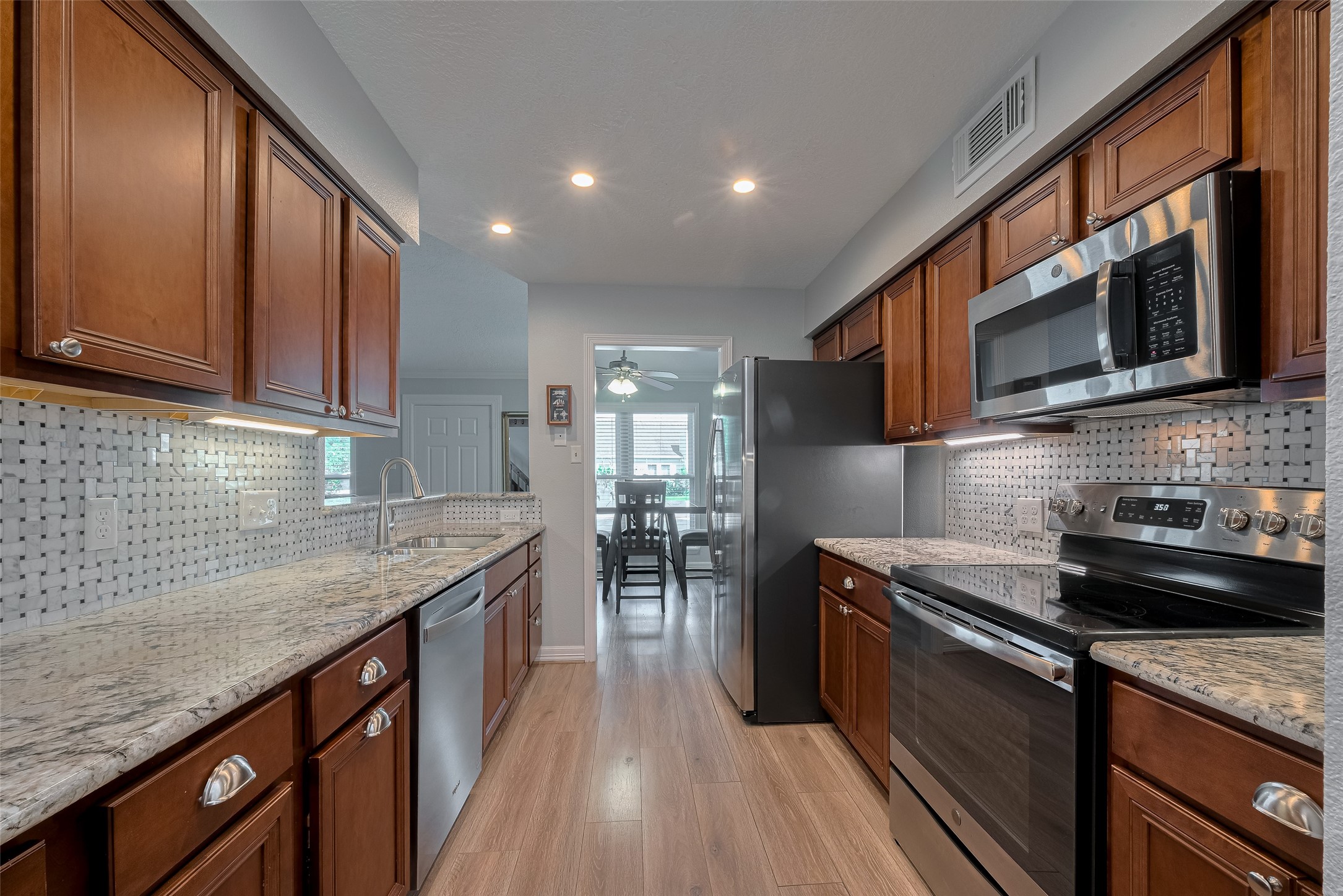 64 Hideaway Drive Friendswood, TX 77546 - Photo 9 of 33 a kitchen with stainless steel appliances granite countertop a sink stove and cabinets