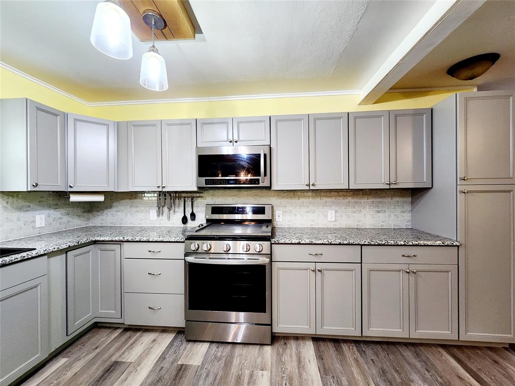 3514 Buchanan Loop Road Texarkana, TX 75501 - Photo 9 of 40 a kitchen with stainless steel appliances granite countertop a stove a sink and a microwave