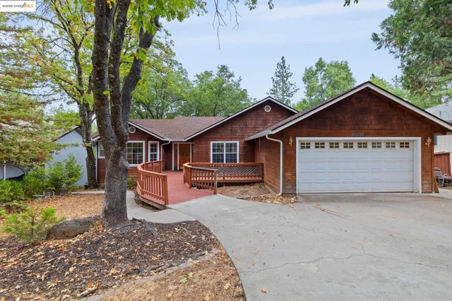 a view of a house with a yard and large tree