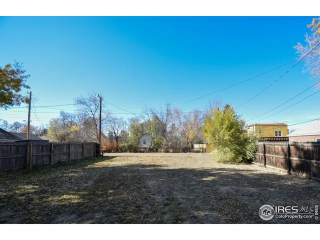 a view of a backyard with wooden fence