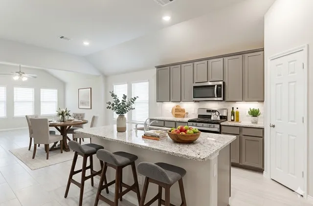 a kitchen with a table chairs microwave and cabinets