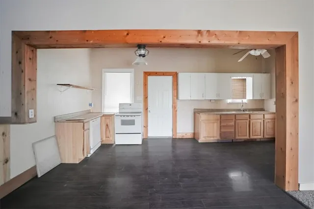 a kitchen with cabinets and wooden floor