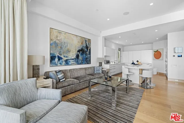 a living room with furniture and view of kitchen