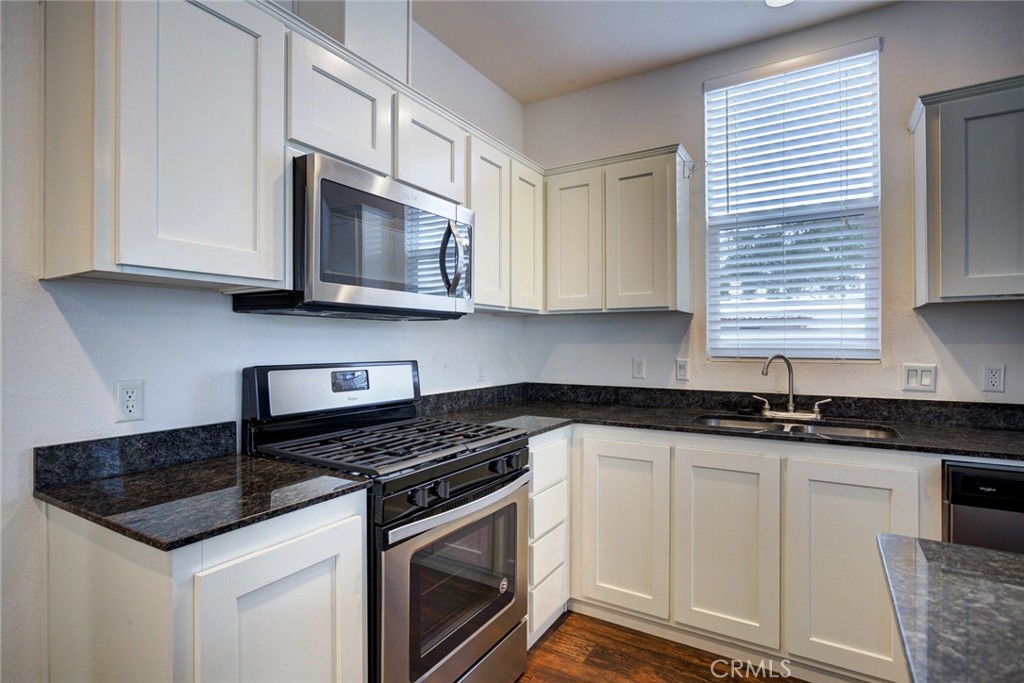 1701 Los Osos Valley Road, Unit 19 Los Osos, CA 93402 - Photo 2 of 31 a kitchen with granite countertop white cabinets stainless steel appliances and a sink