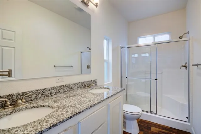 a bathroom with a granite countertop sink toilet and shower