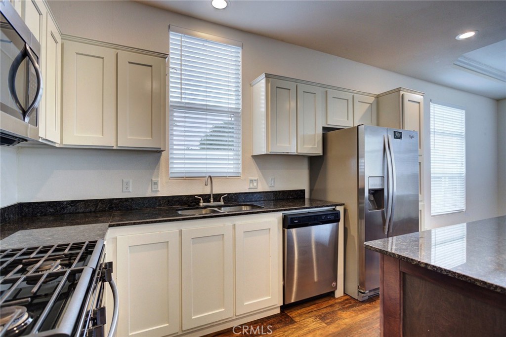 1701 Los Osos Valley Road, Unit 19 Los Osos, CA 93402 - Photo 6 of 31 a kitchen with granite countertop a refrigerator a sink and white cabinets