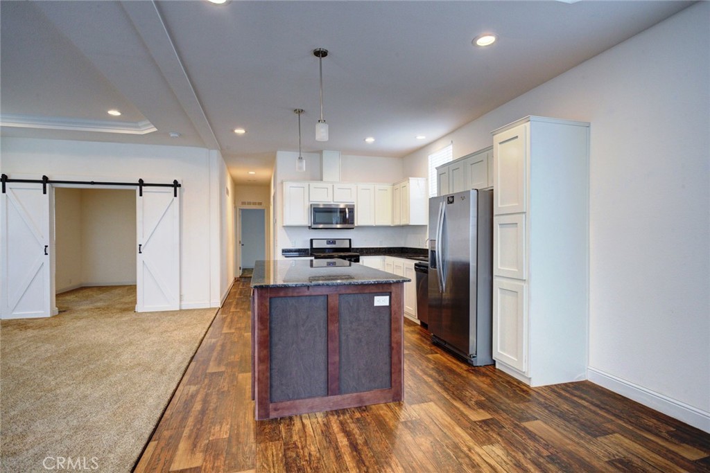 1701 Los Osos Valley Road, Unit 19 Los Osos, CA 93402 - Photo 8 of 31 a large kitchen with stainless steel appliances kitchen island granite countertop a refrigerator and a sink