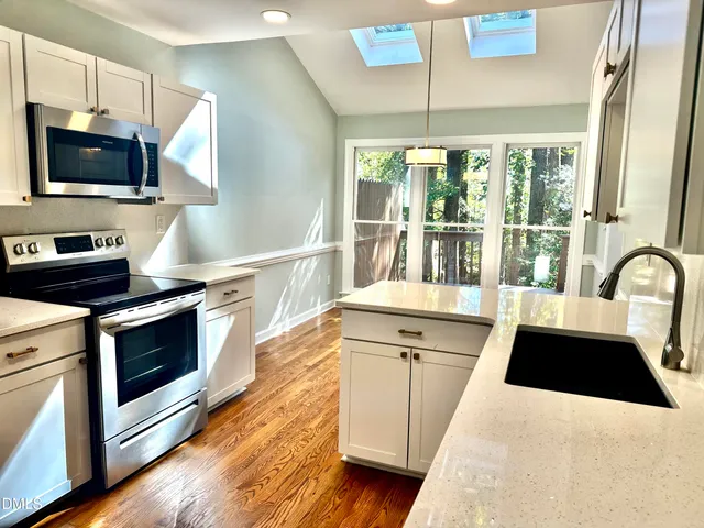 a kitchen with granite countertop a refrigerator and a stove top oven