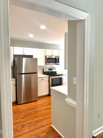 a view of a hallway with wooden floor and staircase