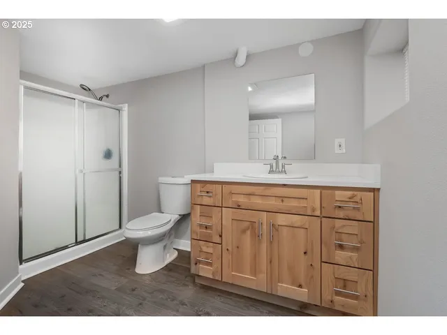 a bathroom with a granite countertop sink toilet and shower