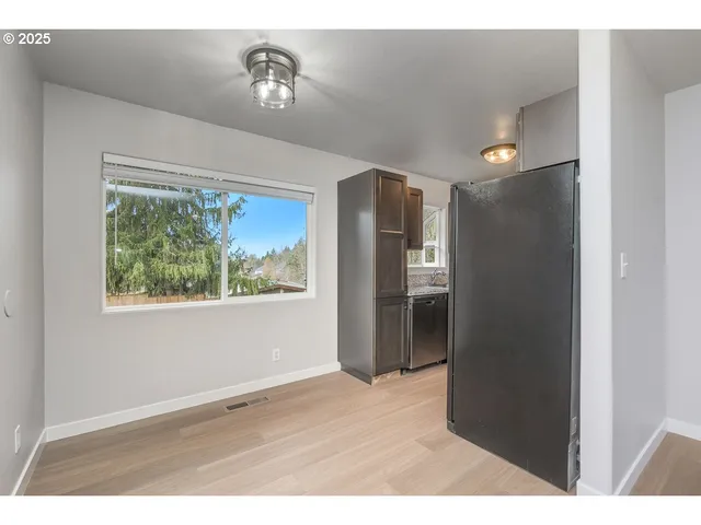 a view of an empty room with closet and a window