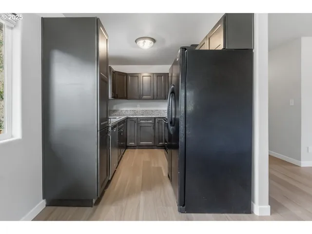 a kitchen with kitchen island a refrigerator and a sink