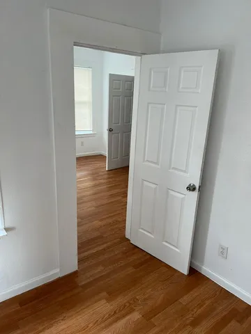an empty room with wooden floor and closet