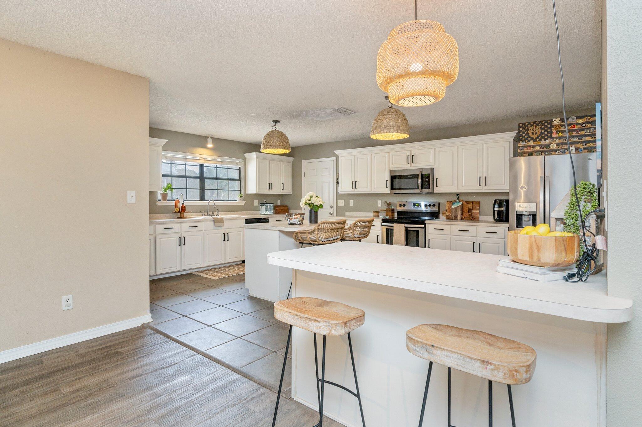 5938 Ridgeview Drive Milton, FL 32570 - Photo 17 of 58 a kitchen with stainless steel appliances granite countertop a stove a sink a microwave and a refrigerator