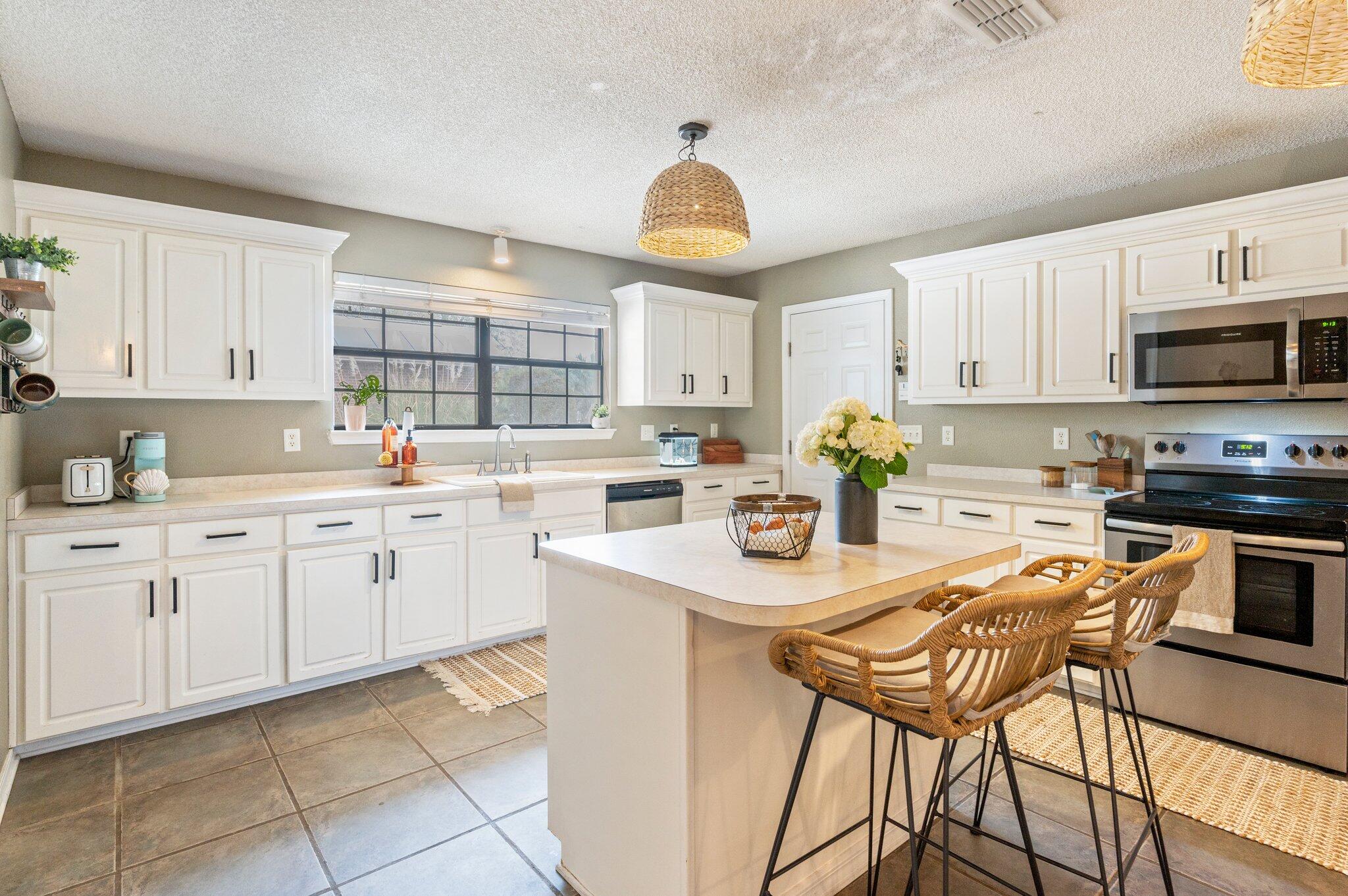 5938 Ridgeview Drive Milton, FL 32570 - Photo 19 of 58 a kitchen with stainless steel appliances kitchen island granite countertop a sink a stove a dining table and chairs