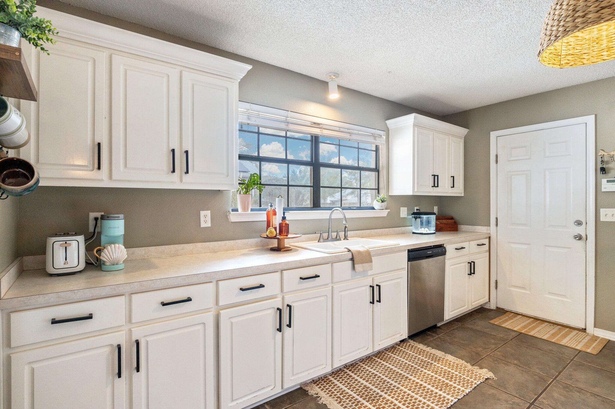 5938 Ridgeview Drive Milton, FL 32570 - Photo 21 of 58 a kitchen with stainless steel appliances granite countertop a sink and a white cabinets