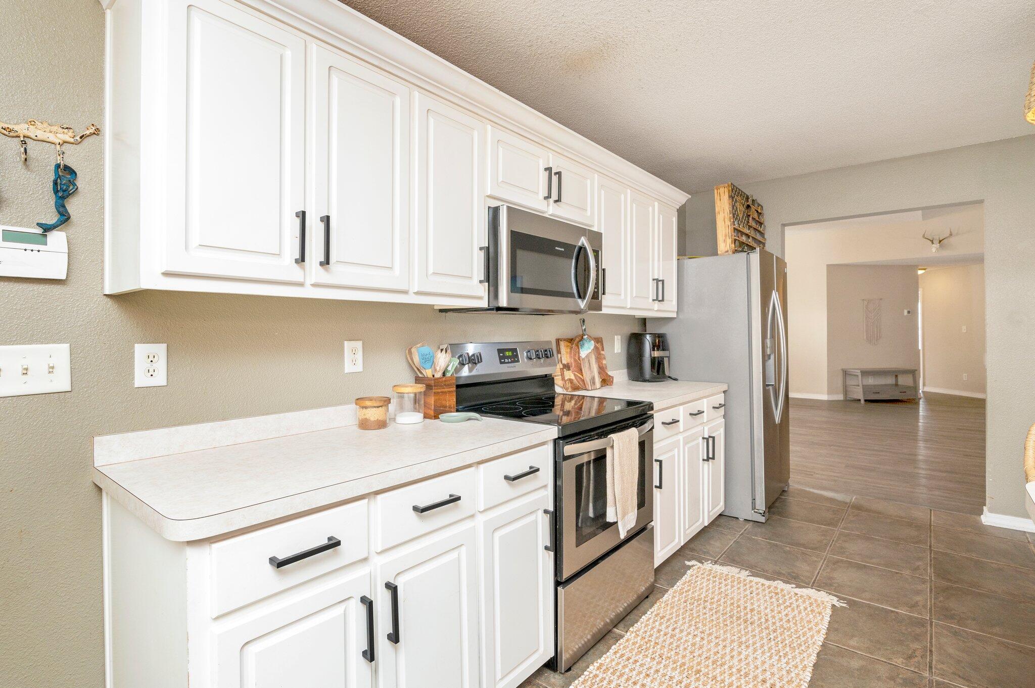 5938 Ridgeview Drive Milton, FL 32570 - Photo 24 of 58 a kitchen with stainless steel appliances granite countertop a stove a sink and a refrigerator