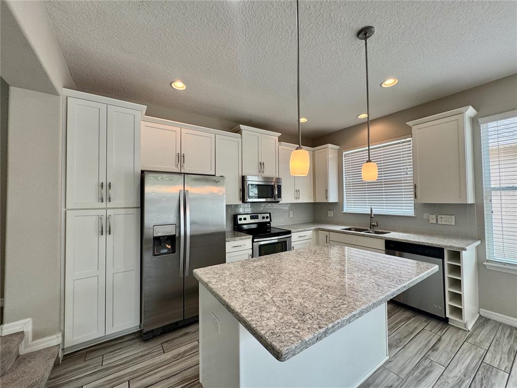 8620 Wellington Blue Lane Windermere, FL 34786 - Photo 8 of 22 a kitchen with stainless steel appliances granite countertop a sink refrigerator and cabinets