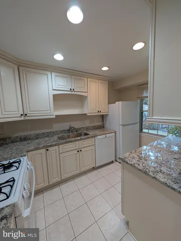 a kitchen with a sink a refrigerator and cabinets
