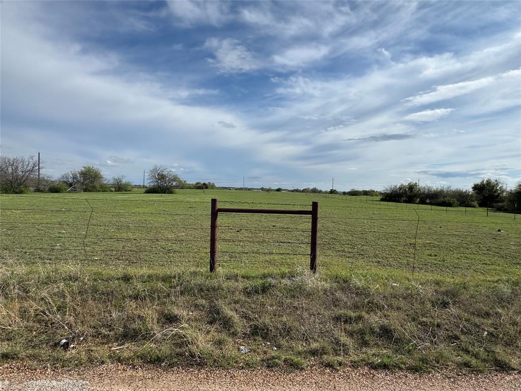 View of yard with fence and a rural view