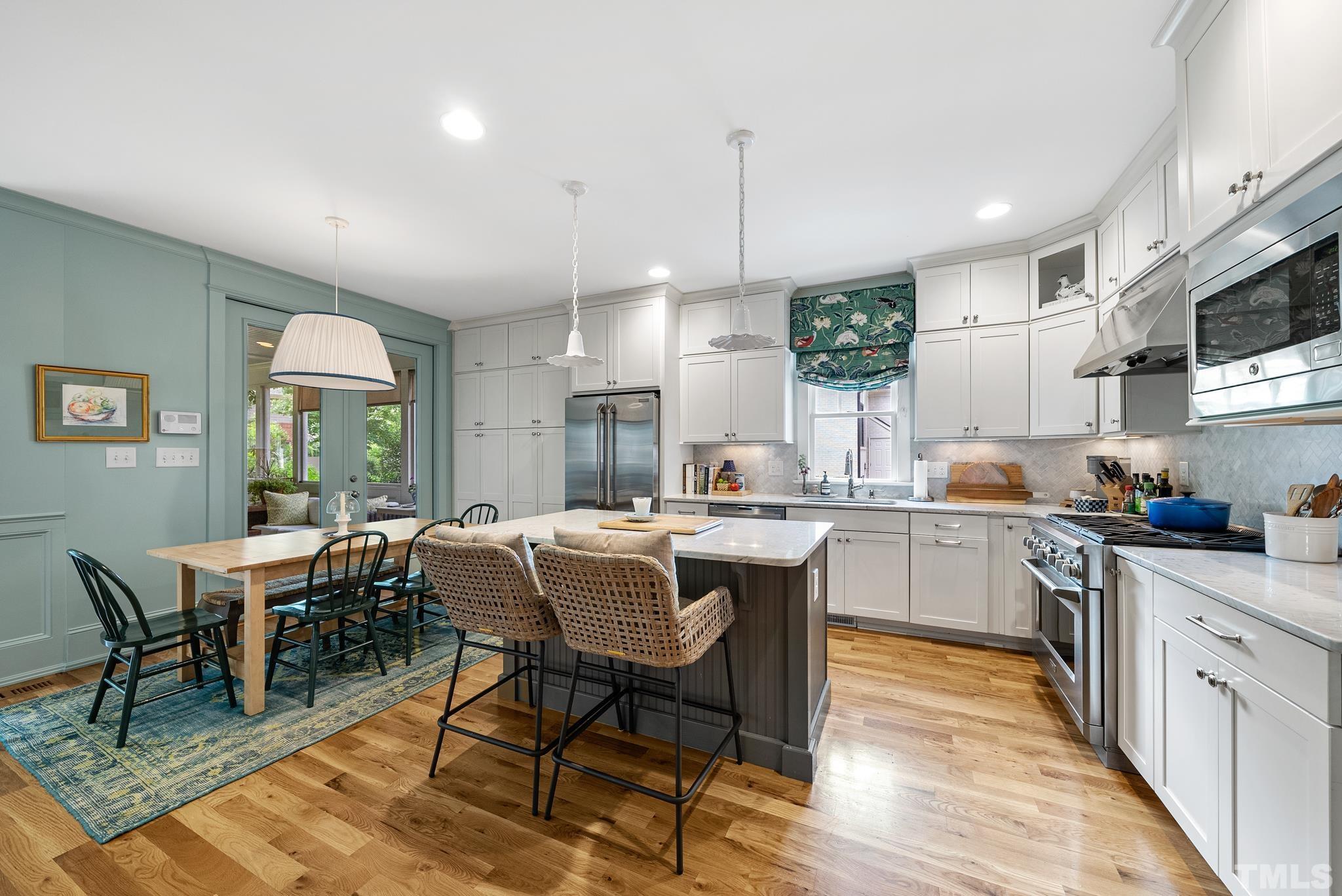 1841 Reaves Drive Raleigh, NC 27608 - Photo 8 of 25 a kitchen with stainless steel appliances granite countertop a table chairs sink refrigerator and cabinets