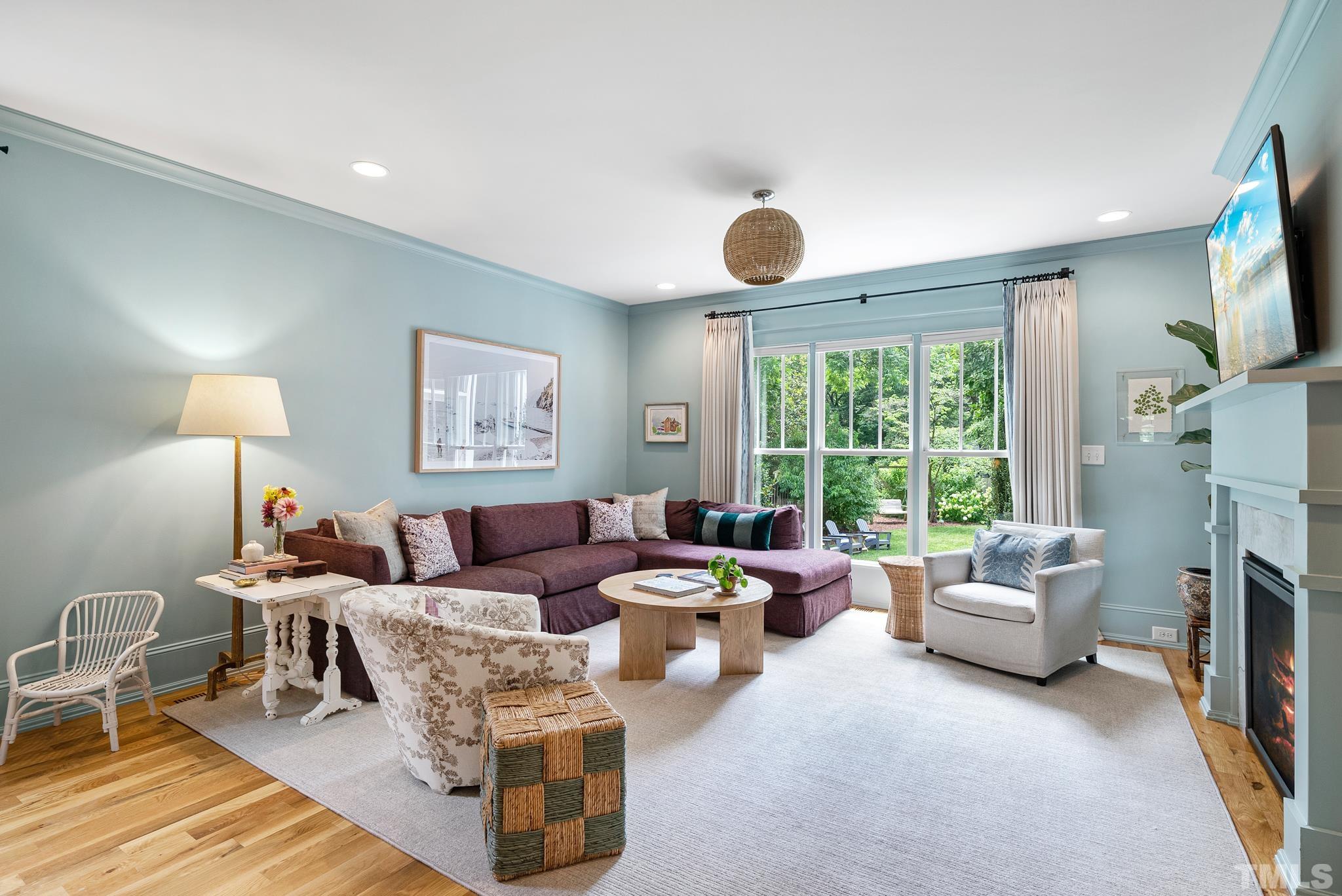 1841 Reaves Drive Raleigh, NC 27608 - Photo 9 of 25 a living room with furniture a fireplace and a large window