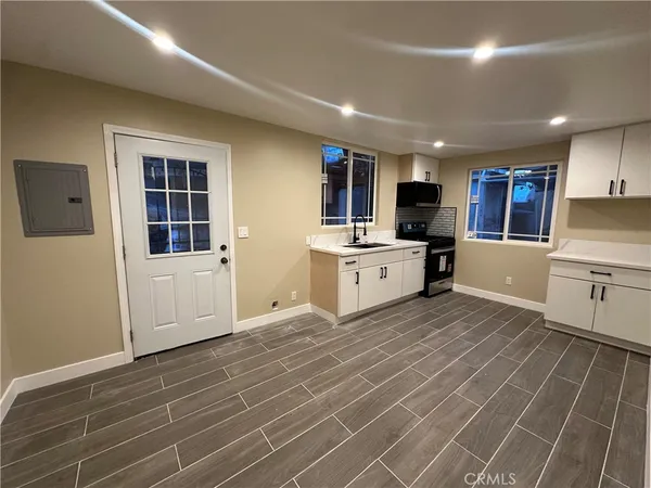 a large kitchen with stainless steel appliances a stove a sink a refrigerator and a microwave