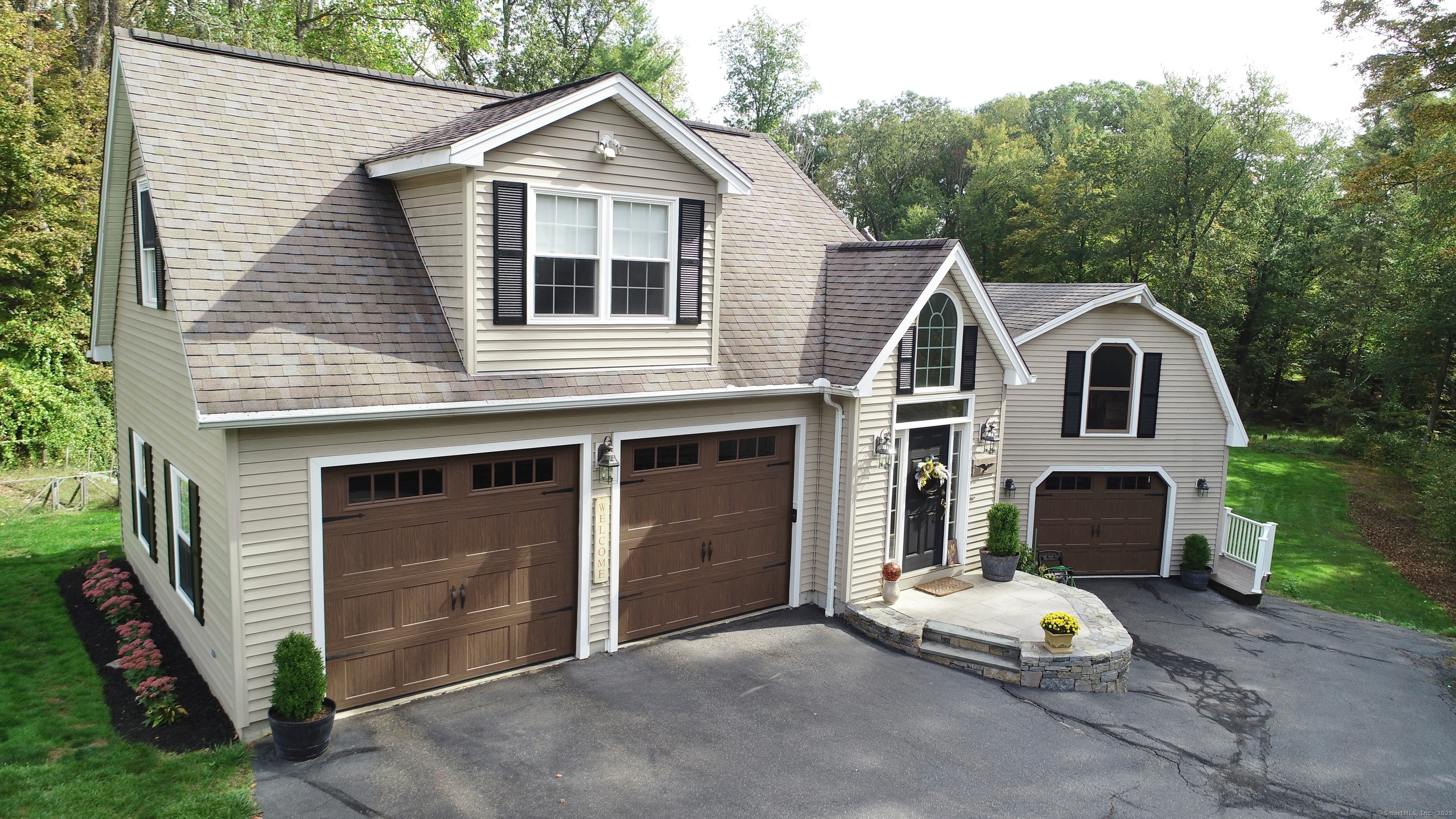 a view of a house with a yard and large tree
