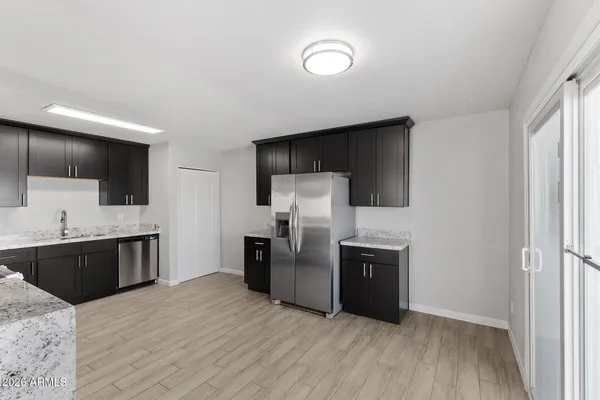 a kitchen with granite countertop a refrigerator and a stove top oven