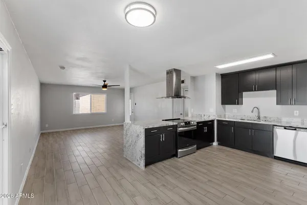 a large kitchen with stainless steel appliances granite countertop a stove a sink dishwasher and a black refrigerator