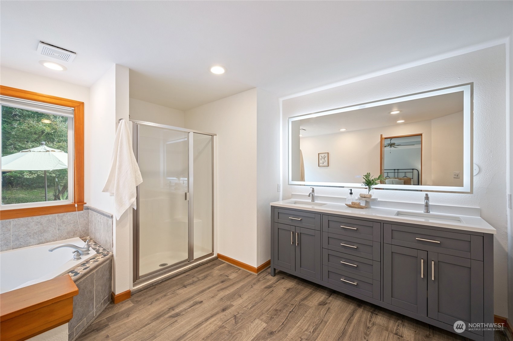 5730 Sand Road Bellingham, WA 98226 - Photo 23 of 40 a bathroom with a tub a sink and a large mirror