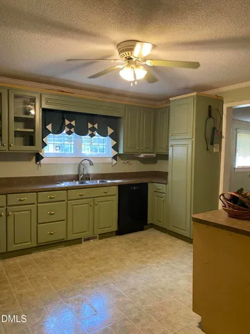 a kitchen with kitchen island granite countertop a sink cabinets and stainless steel appliances